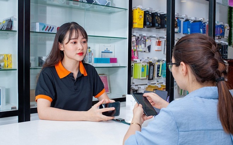 Nhân viên bán điện thoại tư vấn và hỗ trợ khách chọn smartphone phù hợp
